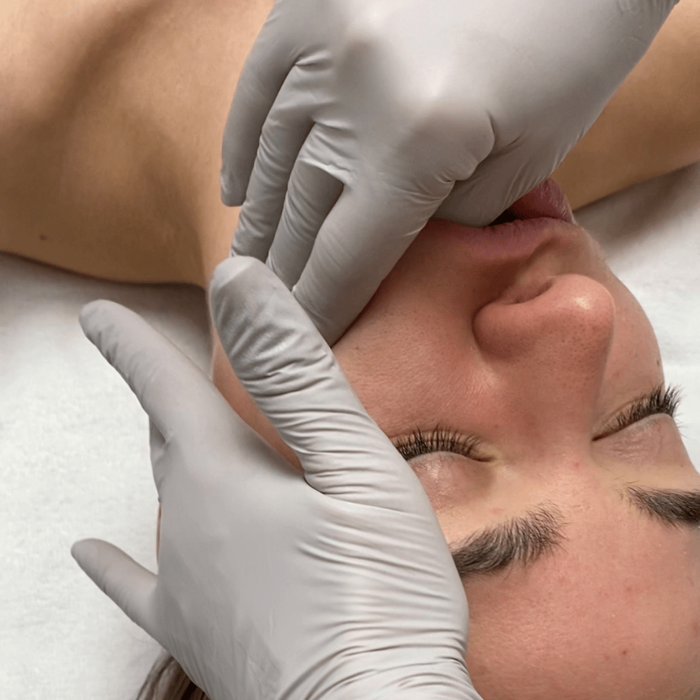 Therapist performing an intraoral TMJ massage technique on a client